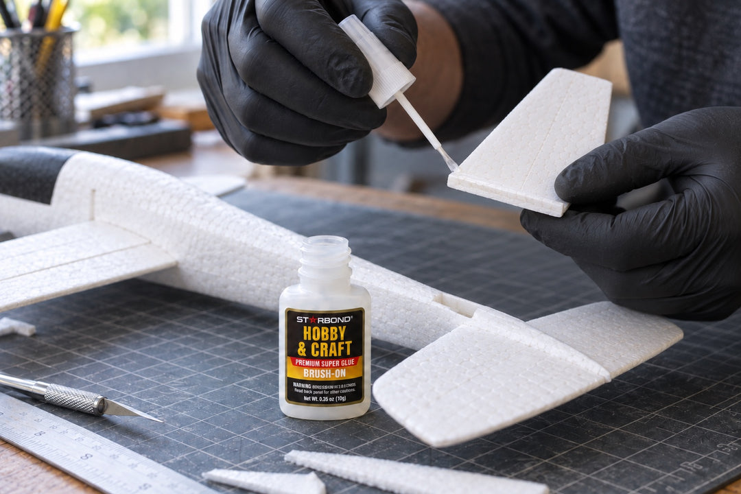 Hands carefully assembling a balsa-wood model airplane wing on a craft workbench.